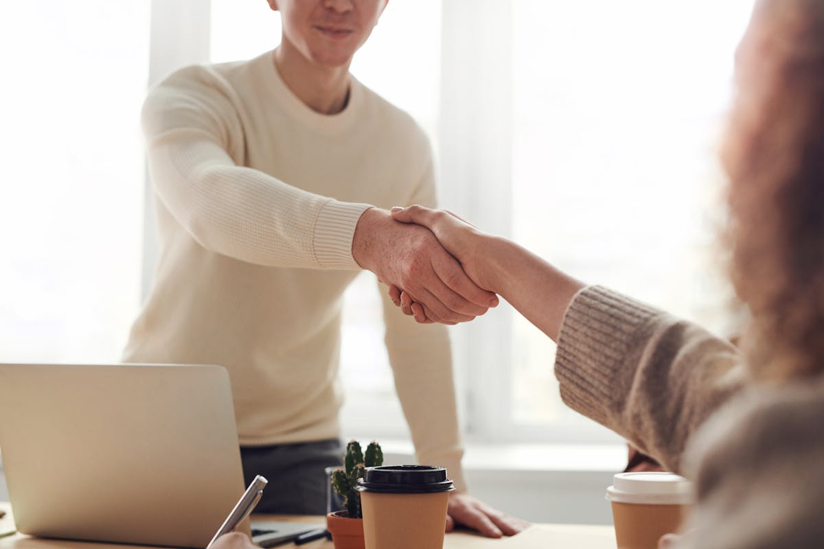Home buyer and seller shaking hands across a table